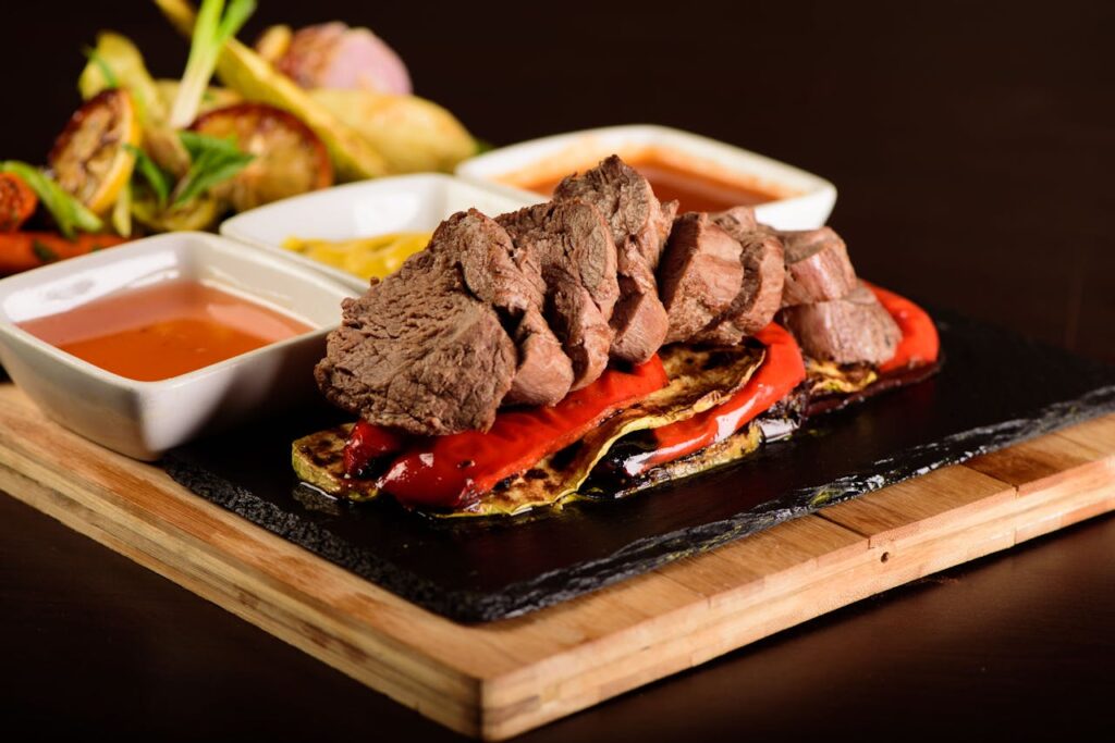 pexels-photo-18214697 A delicious gourmet steak with grilled vegetables and various sauces. Perfectly styled for food photography.
